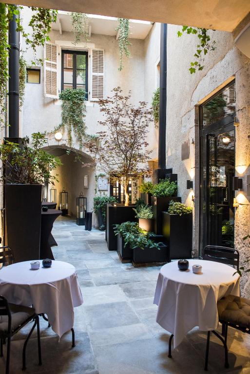 Petit Hôtel Confidentiel — planted interior courtyard with café tables