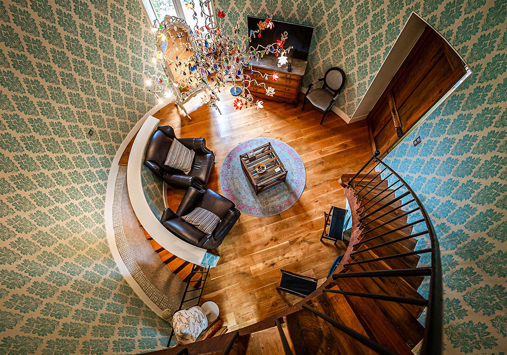 Château de Candie | a sitting room with chandelier and patterned wallpaper