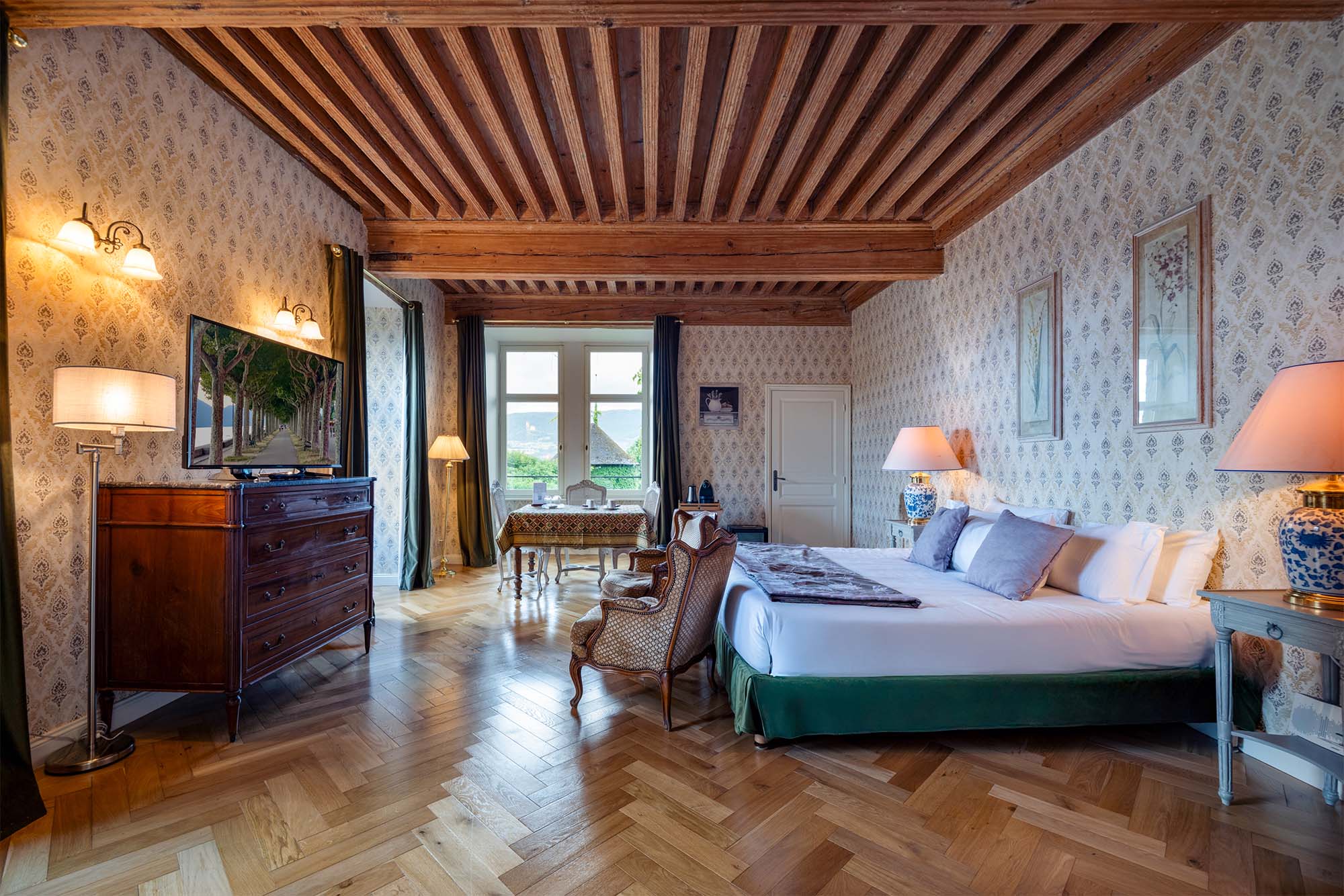 Château de Candie | a beamed bedroom with garden views